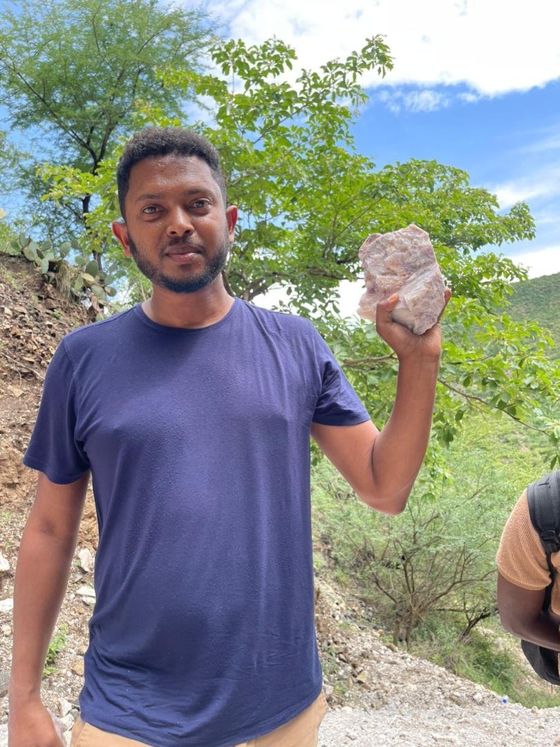 Team member holding a piece of lithium-bearing ore